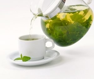 image of teapot with cup of green tea