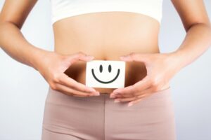 image of woman with smiley face on belly - calcium and colon cancer