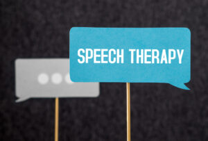 Suzy Cohen 47 Sign holding speech therapy indicating care for aphasia and apraxia