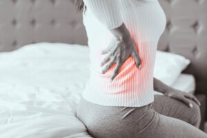 Woman holding her side due to flank pain from kidney stones