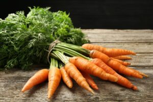 photo of carrots with tops on a cutting board