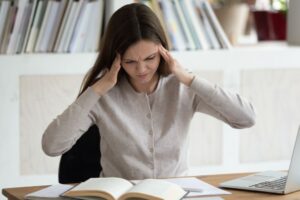 woman distracted at her desk due to focus issues and possibly low dopamine