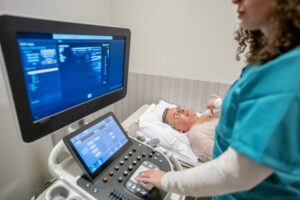 woman receiving echocardiogram by technician